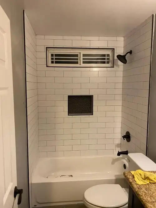 Bathroom remodel with a white subway tile shower by TCS Construction